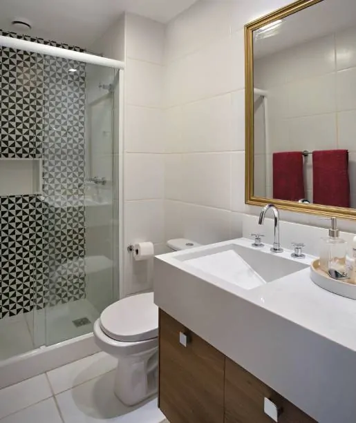 Banheiro pequeno com detalhe de revestimento preto e branco no box