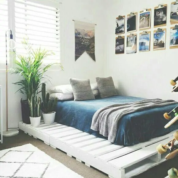 Quarto alternativo, com cama de pallets, e fotografias nas paredes
