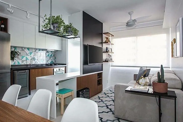 Sala simples integrada com a cozinha, com prateleiras e sofá grande
